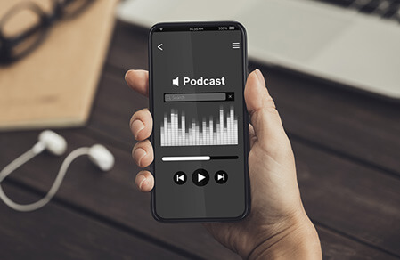 Hand holding smart phone showing a podcast playing