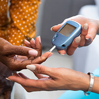 Close-up of one set of diverse female hands testing the blood of another using BGM