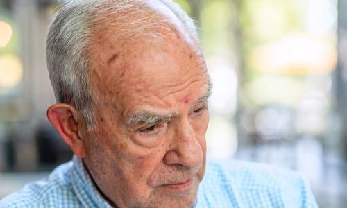 Close-up of a male senior citizen's face at an angle looking downward